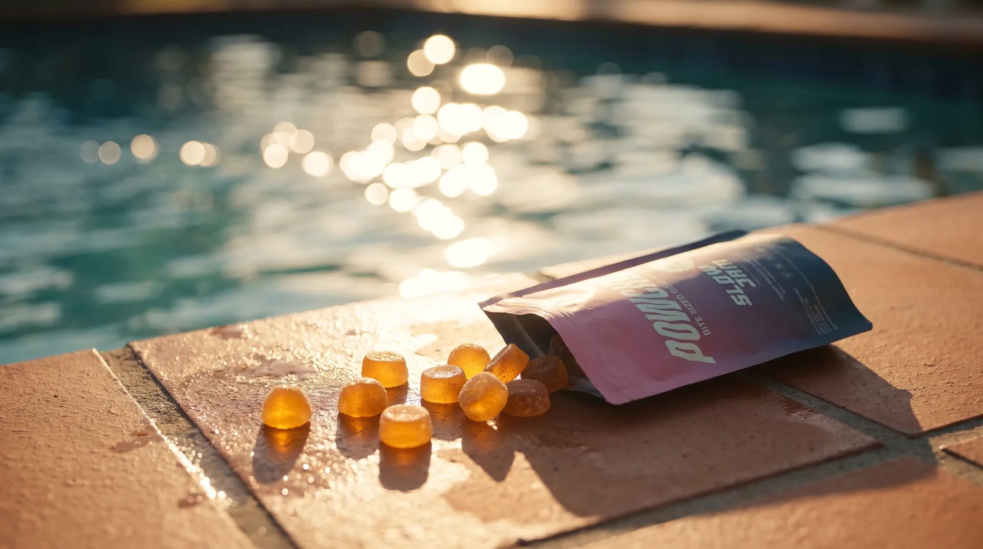 Slow Jam gummies tipped out of the pouch on a sunlit pool deck
